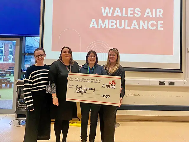Staff at Ysgol Gymraeg Caerffili handing over a cheque for &pound;1,500