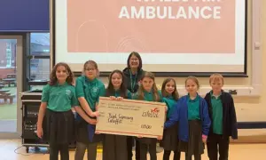 Pupils at Ysgol Gymraeg Caerffili handing over a cheque for £1,500