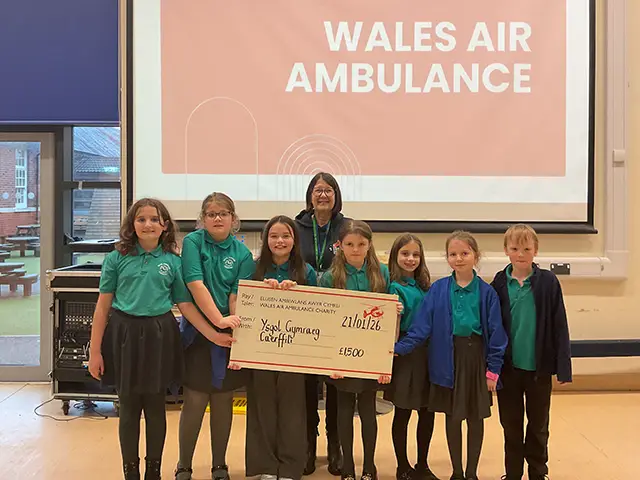 Pupils at Ysgol Gymraeg Caerffili handing over a cheque for £1,500