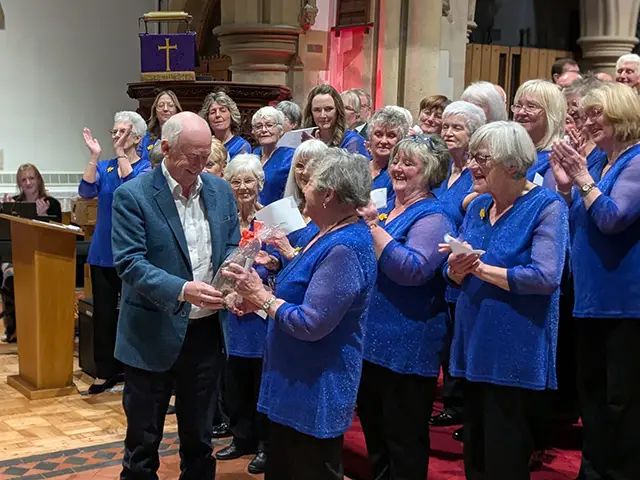 Sir Wayne David presenting Marjorie Gray with a special gift to celebrate her longevity in the choir