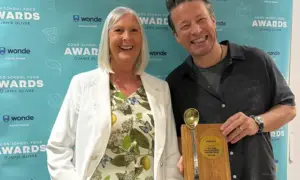 Phyllis Levi receiving her award off Jamie Oliver
