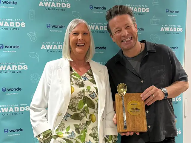 Phyllis Levi receiving her award off Jamie Oliver