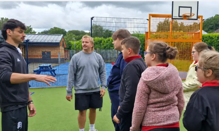 Will Bishop, left, speaking with pupils at Trinity Fields School